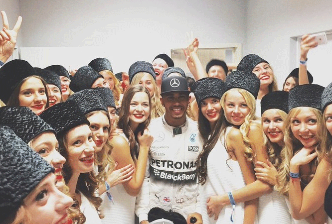 Lewis Hamilton não perdeu a oportunidade de tirar foto com as modelos após a corrida. FOTO: globoesporte.globo.com.
